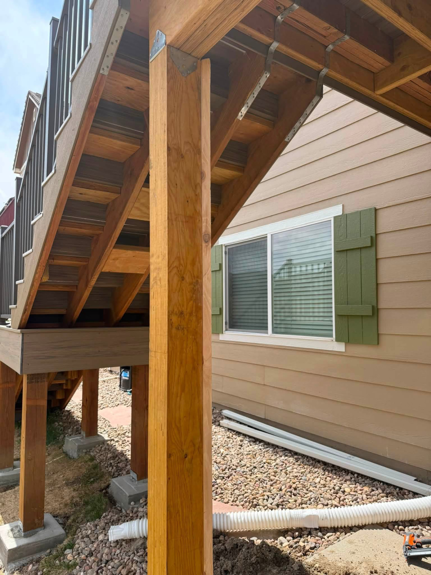 Deck staircase framing with support posts, stringers and metal hangers