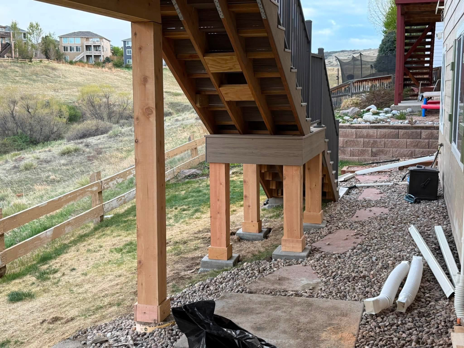Deck stair landing with wood support posts on concrete footings
