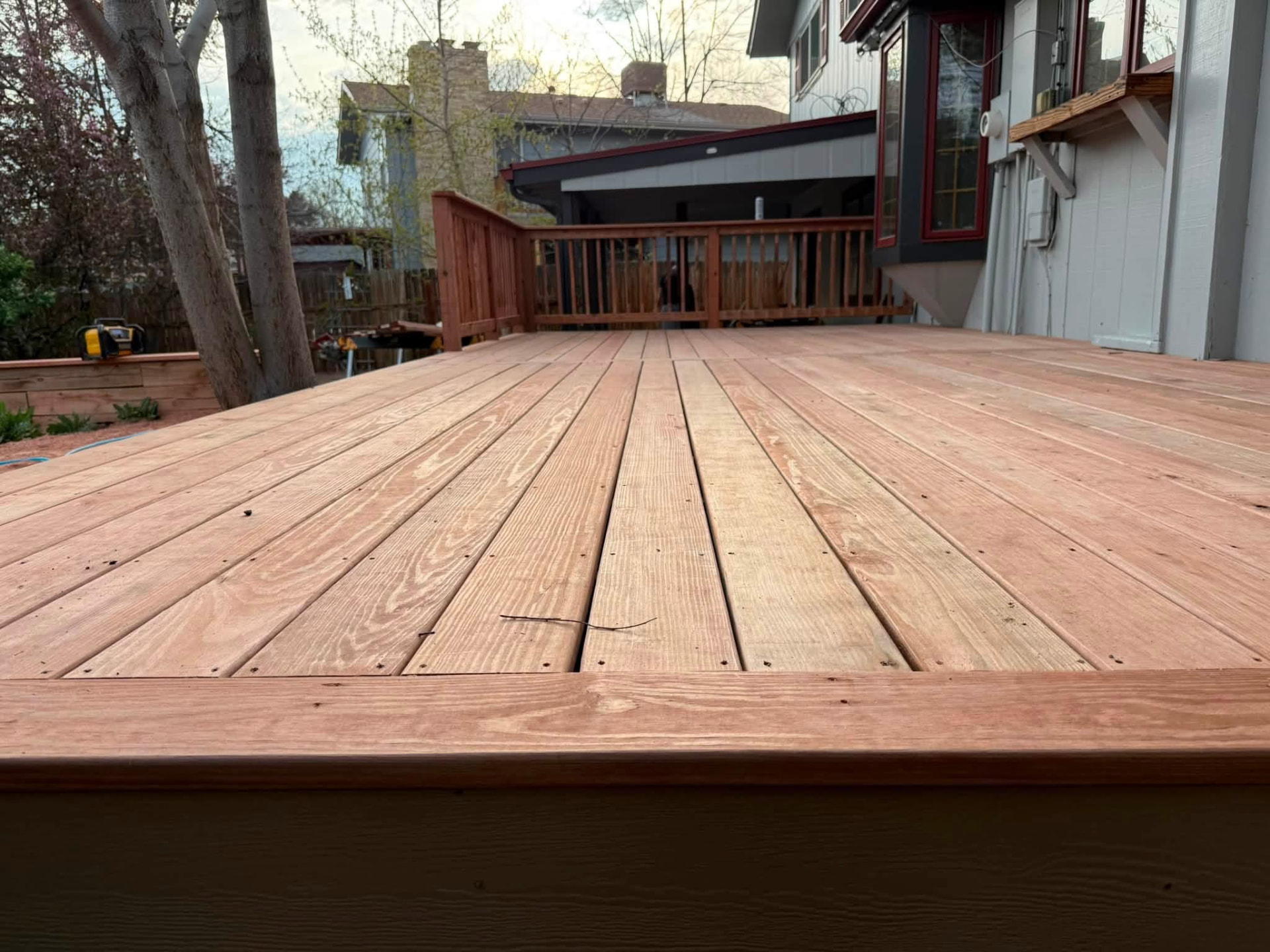 New wood deck boards with a picture-frame border and installed railing