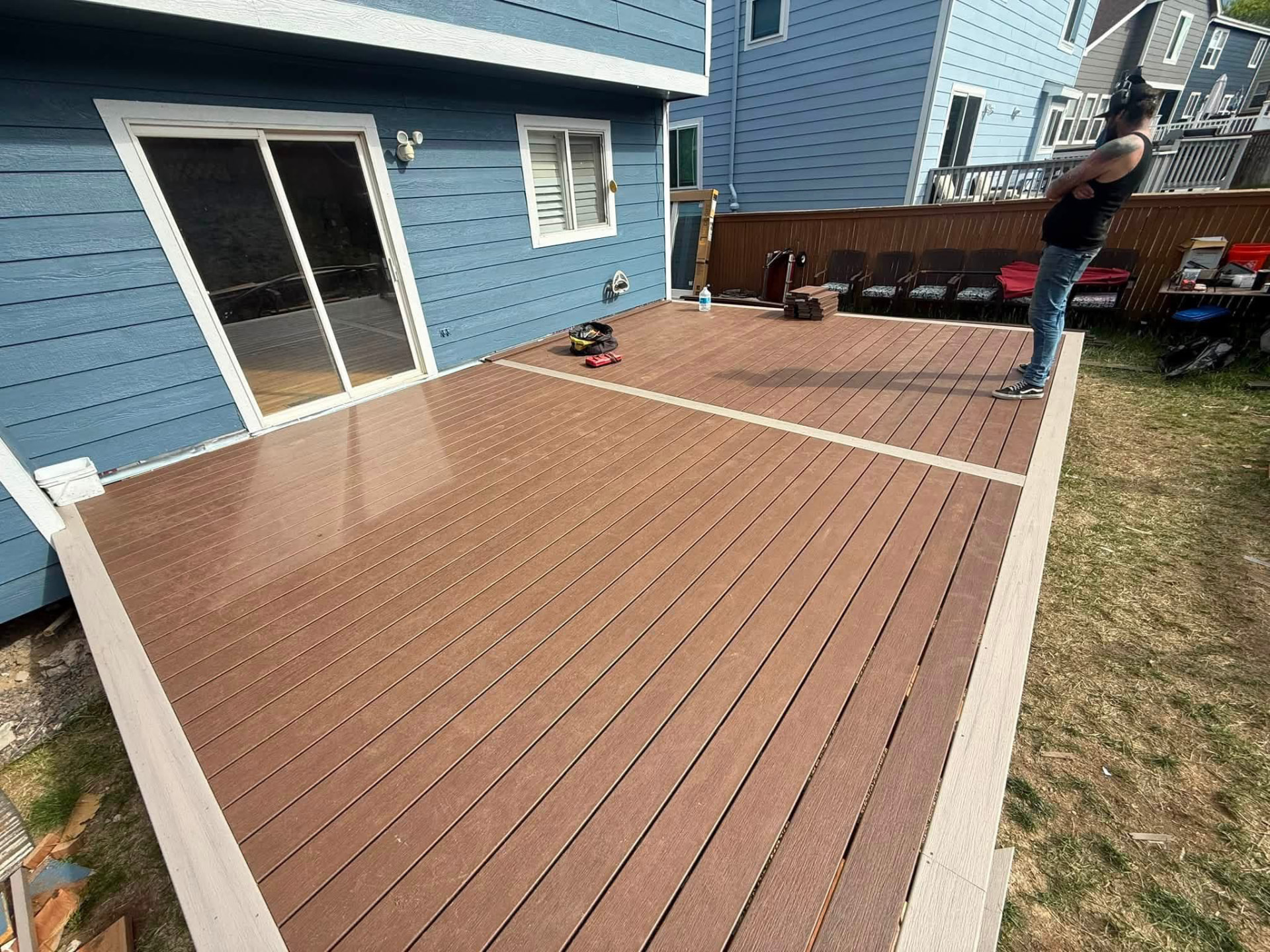 Finished low backyard deck with brown composite boards and a light picture-frame border